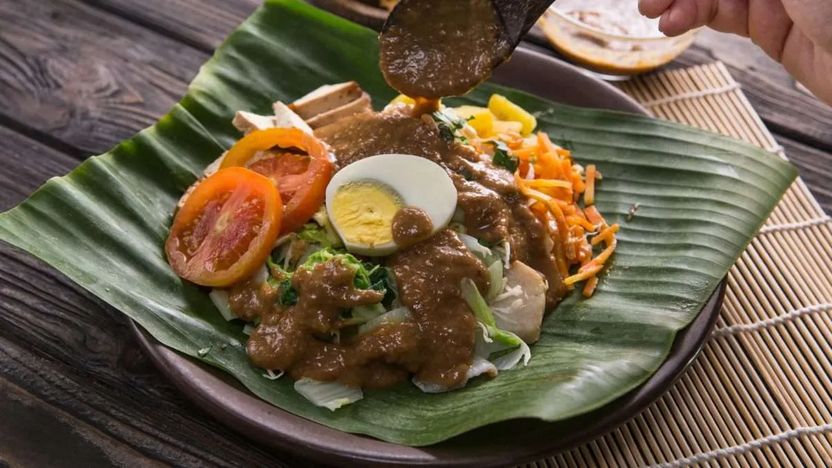 Gado-Gado Indonesian Salad on wood plate and banana leaves